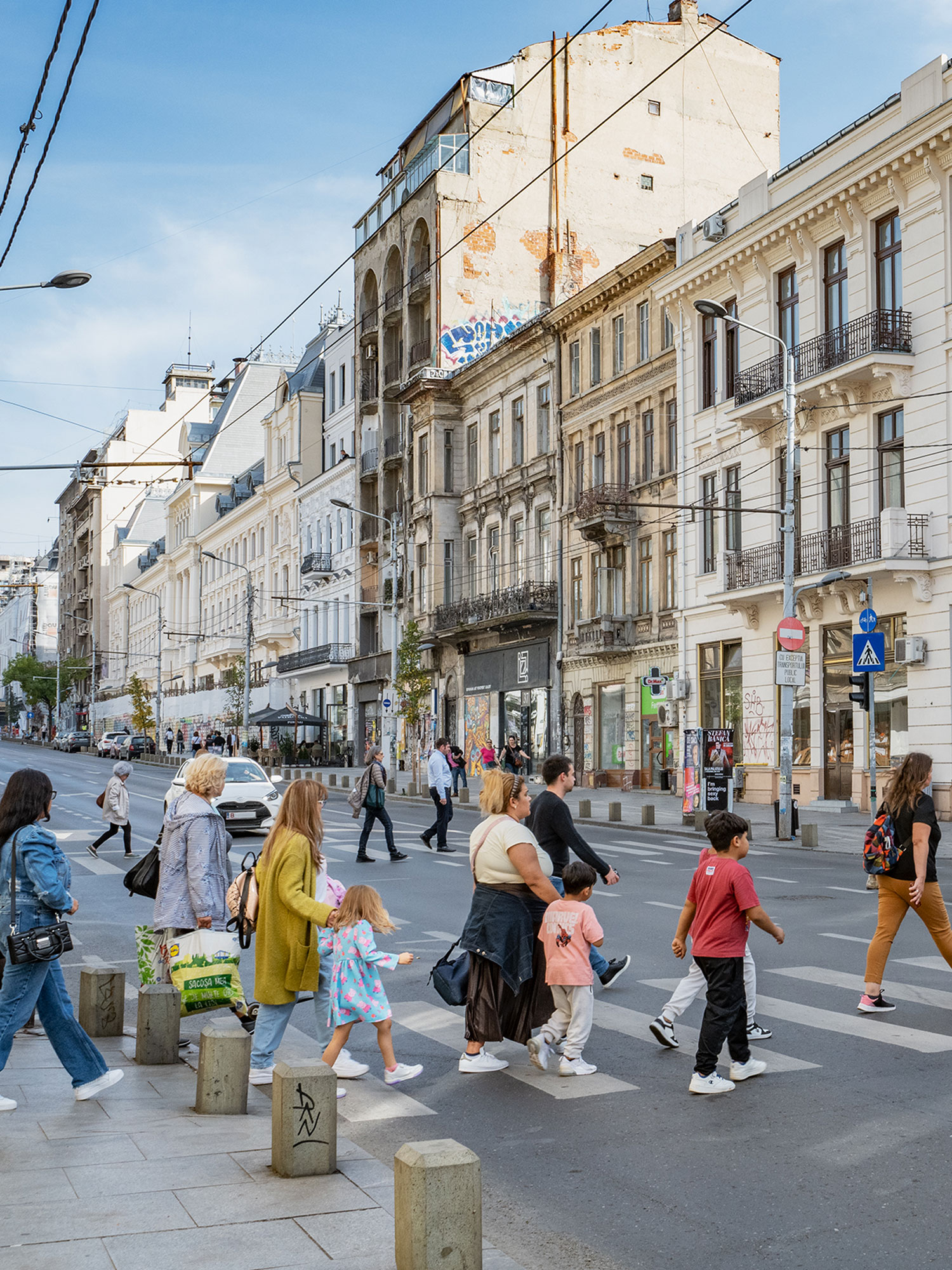 A busy street in Bucharest: pedestrians cross the street.