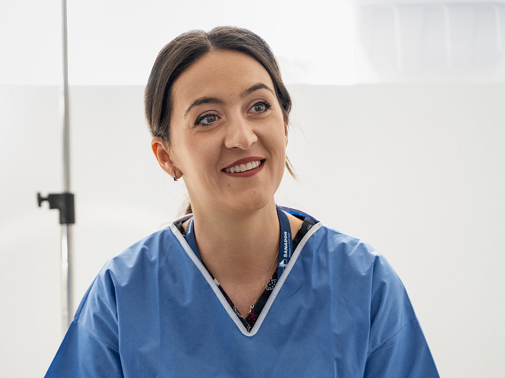 Portrait of Dr. Andrea Costache, a slim female doctor with dark hair and blue surgical attire